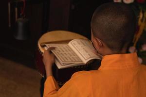 Bandung City, Indonesia, 2022 - The monks sitting on the chair while praying on the altar in orange costumes photo