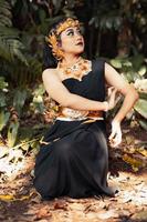 Indian woman wearing a black dress with a golden crown and golden necklace on her body photo