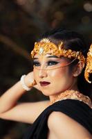 The face of a Balinese woman wearing a gold crown and make-up on her face with beautiful skin chilling photo