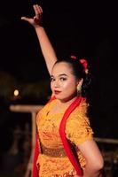 Indonesian women wearing traditional dance costumes called kebaya and pose with dancing moves in the night photo