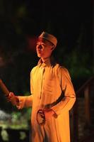 A Muslim man lighten up the campsite with the fire torch in his hands photo