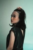 modelo asiático posando tocando su cabello negro y sintiéndose sexy y caliente foto
