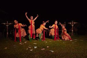 bailarines javaneses con hermoso maquillaje y traje tradicional mientras bailan la danza tradicional en el escenario foto