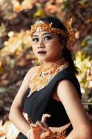 Beautiful exotic woman with a golden headpiece and golden necklace on her body while wearing makeup photo