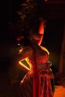 mujeres balinesas vistiendo ropa cultural mientras posan frente a la iluminación con movimientos de baile foto