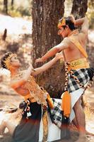 Two Asian men pose together with the gold crown in their hands and wearing striped clothes photo