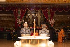 Bandung City, Indonesia, 2022 - The offerings like food and candle on the top of the red Buddhist table during the praying from the monks photo
