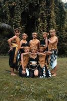 A Group of Balinese people poses together with a happy face while wearing golden costumes after the performance photo