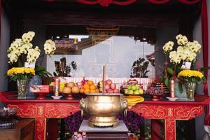 Bandung City, Indonesia, 2022 - The offerings like food and candle on the top of the red Buddhist table during the praying from the monks photo