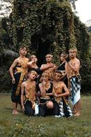 A bunch of Asian people having fun while taking a photo shoot with a golden dance costume in front of the jungle