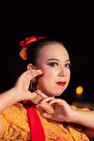 Exotic Javanese woman wearing beautiful makeup with red lips while wearing a traditional yellow costume and red scarf photo