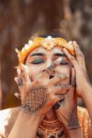 A Man covering his mouth with his hand while in golden accessories photo