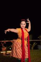 Sundanese woman with an exotic face wearing a yellow dress and red scarf during a dance exhibition photo