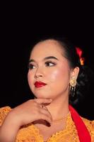 Beautiful face of an Asian woman with red lips and makeup in Indonesian traditional dance costume after the dance performance photo