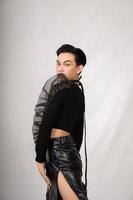 Asian man poses in a black costume while wearing makeup and black hair photo