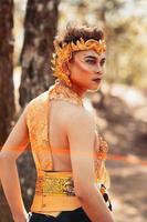 Manly Asian man posing in a golden crown and golden clothes while wearing makeup photo