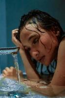 Asian Women hold hear heads near the faucet and water flow from it photo