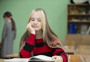 Teenager of senior school age. Teenage girl at her desk with a book. photo