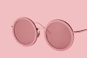 Pink sunglasses on a pink background.Glasses and background of the same color. photo