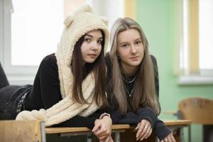 Two girlfriends teenage girls posing and looking at the camera. The girls are fifteen years old. Senior students. photo