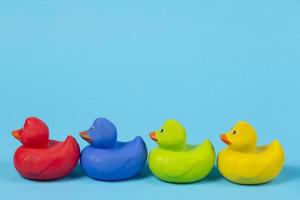 Multi-colored rubber ducks on a blue background. photo