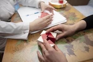 The hands of a psychologist doctor and the patient's hands. Psychologist conducts a test with cubes.The psychologist identifies problems. photo