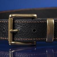 Black leather belt on a dark blue background. photo