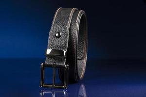 Black leather belt on a dark blue background. photo