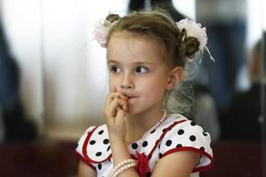 Little girl bites her nails. photo