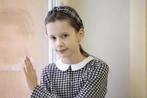 Beautiful girl ten years old. Schoolgirl at the window. photo