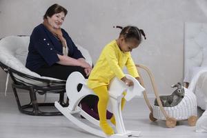 Grandmother and granddaughter from different races. The fair-skinned grandmother plays with the dark-skinned granddaughter. photo