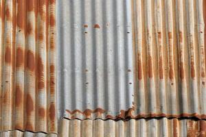 Artistic of old and rusty zinc sheet wall. Vintage style metal sheet roof texture. Pattern of old metal sheet. Rusting metal or siding. Corrosion of galvanized. Background and texture in retro concept photo