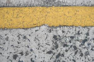 Old road background with yellow lines peeling off from aging. photo