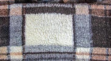 Abstract background with geometric pattern of faux fur plush fleece surface close-up. Brown fluffy fabric. photo