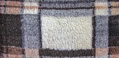 Abstract background with geometric pattern of faux fur plush fleece surface close-up. Brown fluffy fabric. photo