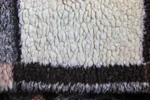 Abstract background with geometric pattern of faux fur plush fleece surface close-up. Brown fluffy fabric. photo