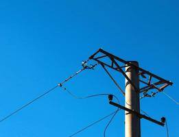 poste eléctrico con un cable lineal contra el primer plano del cielo azul. poste eléctrico de potencia. foto