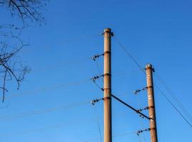 poste eléctrico con un cable lineal contra el primer plano del cielo azul. poste eléctrico de potencia. foto