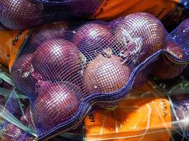 cebollas rojas y amarillas en una bolsa lista para la venta foto