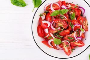 Tomato salad with basil and red onions. Homemade food.  Concept healthy meal. Vegan cuisine. Top view photo