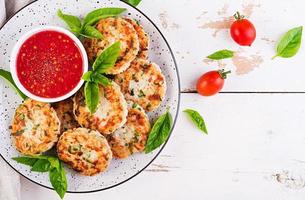 Delicious rice and chicken meat patties with garlic tomato sauce. Top view. Diet food. Copy space photo