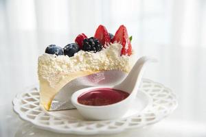 Cheese cake topped with mix berries and strawberry flavour topping photo