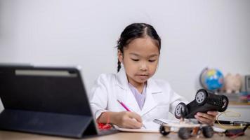 Asian students learn at home by coding robot cars and electronic board cables in STEM, STEAM, mathematics engineering science technology computer code in robotics for kids' concepts. photo