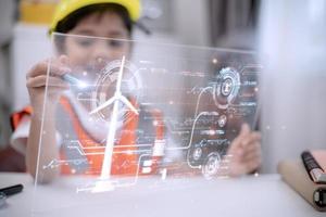 Asian little girl Works with Wind Turbine Prototype virturl, Learning about Environment and Renewable Energy. Children Working on Technology. wind energy concept. STEM Education photo