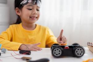 Asia students learn at home in coding robot cars and electronic board cables in STEM, STEAM, mathematics engineering science technology computer code in robotics for kids concept. photo