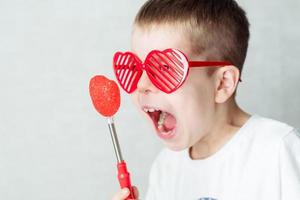 portrait of a boy in glasses in the form of a heart in a white T-shirt against a white background, screaming at the heart. Against valentine's day photo