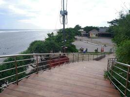 Road or bridge or wooden stairs on the beach , View of the beach bridge in Sayang Heulang Indonesia photo