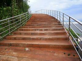 camino o puente o escaleras de madera en la playa, vista del puente de la playa en sayang heulang indonesia foto