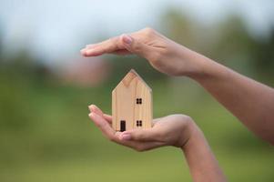 nuevo concepto de hogar - familia joven con modelo a escala de casa de ensueño en las manos foto