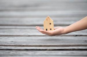 nuevo concepto de hogar - familia joven con modelo a escala de casa de ensueño en las manos foto